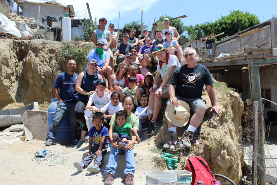 Eindelisa's family, community, and volunteers pose together at a worksite
