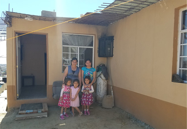 Eugenia and her 4 daughters pose in front of their current home
