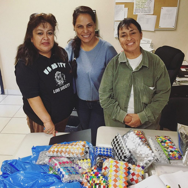 3 Mexican women pose with their pile of small purses made of chip bags