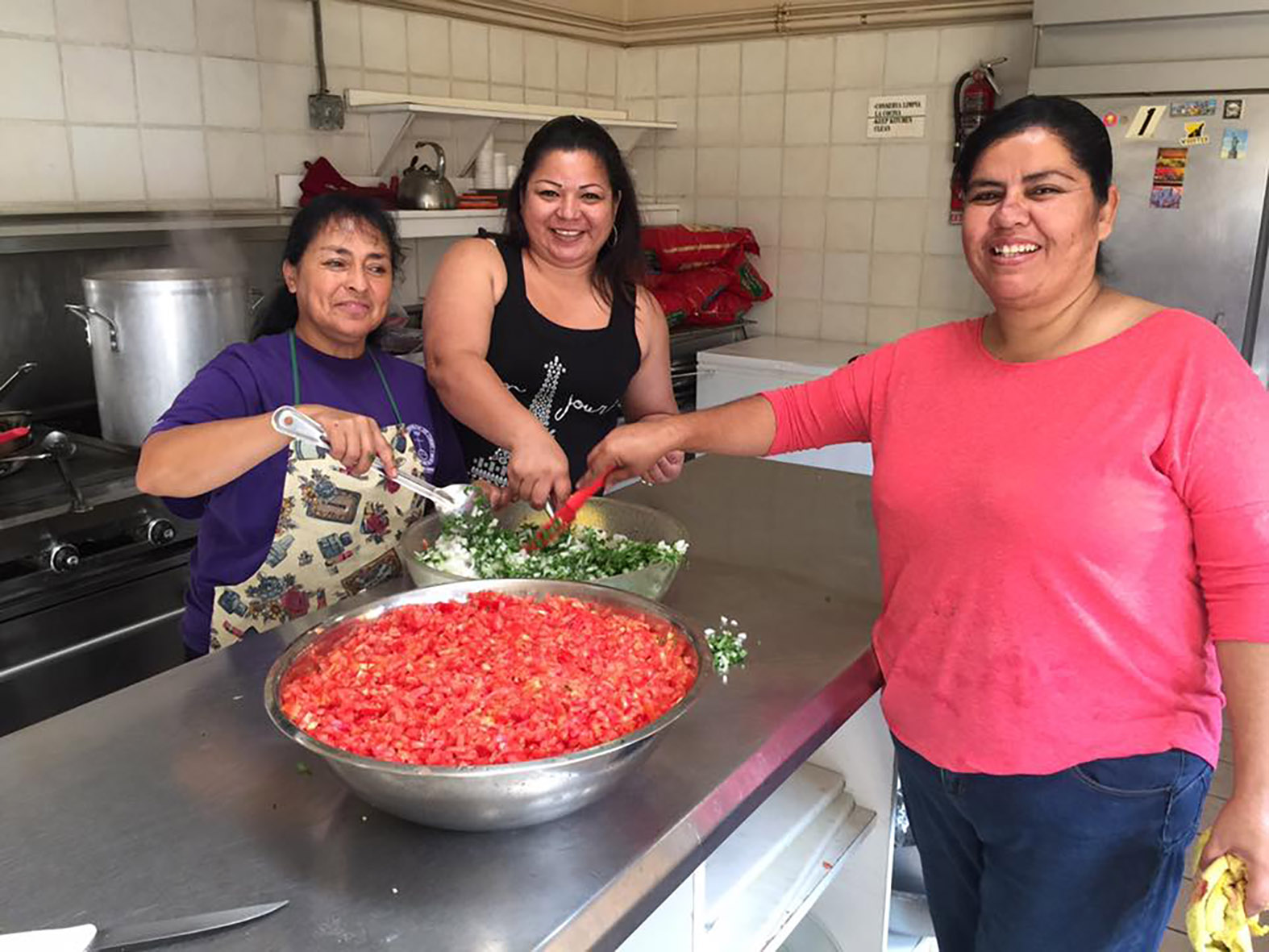 3 women from the community making salsa in the kitchen of la posada