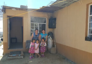 Eugenia and her 4 daughters pose in front of their current home